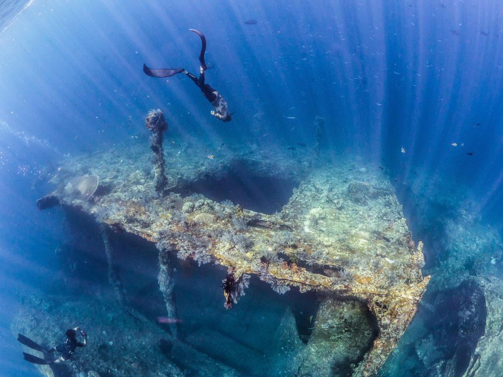 Freediver descends into the Liberty shipwreck in Bali Indonesia.
